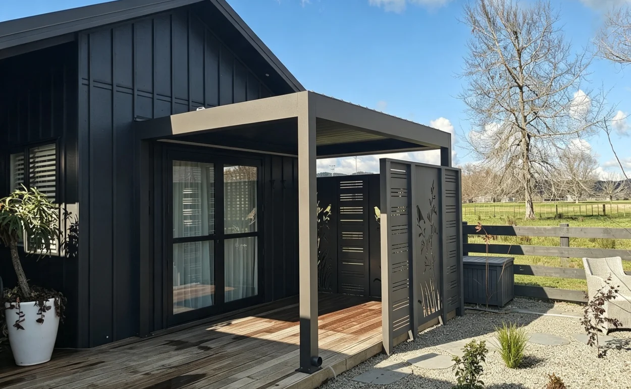 Corner post of a dark louvre roof on a wet timber deck with a round drain outlet at its base